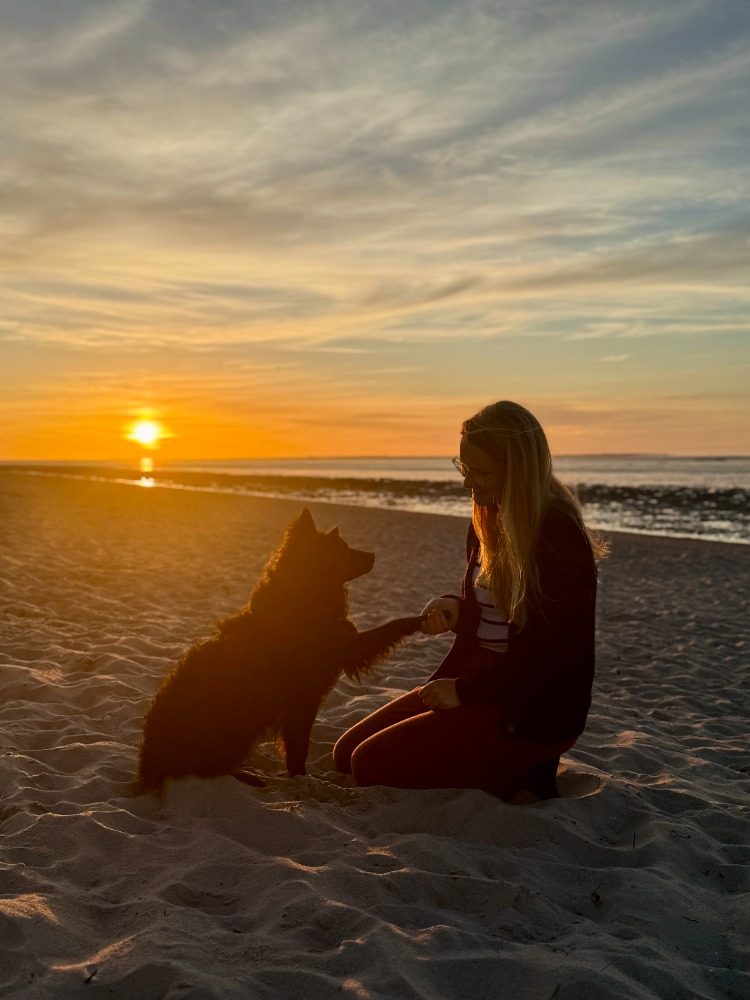 Pippa gibt Klara bei Sonnenuntergang am Strand die Pfote